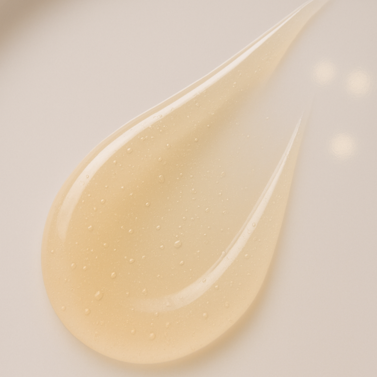 Close-up of a champagne serum on a white background.  Consult Beaute by Dr Terry Dubrow and Heather Dubrow