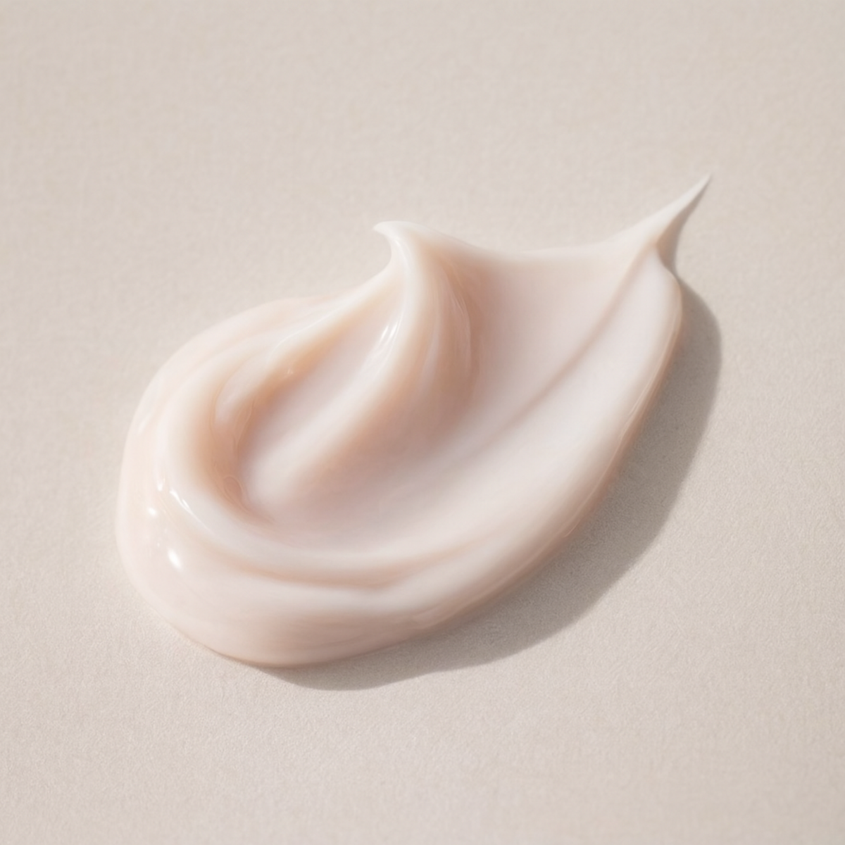 Swirl of champagne cream on a beige background.  Consult Beaute by Dr Terry Dubrow and Heather Dubrow